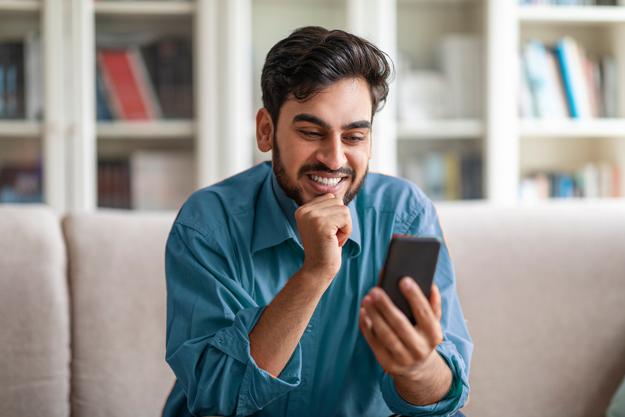 Happy man tracking his finances on phone